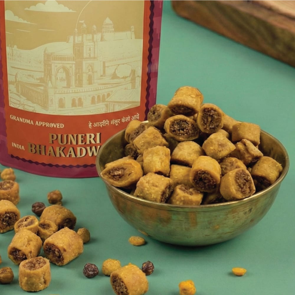 Bowl of Puneri Bhakdwis with packaging on a green background