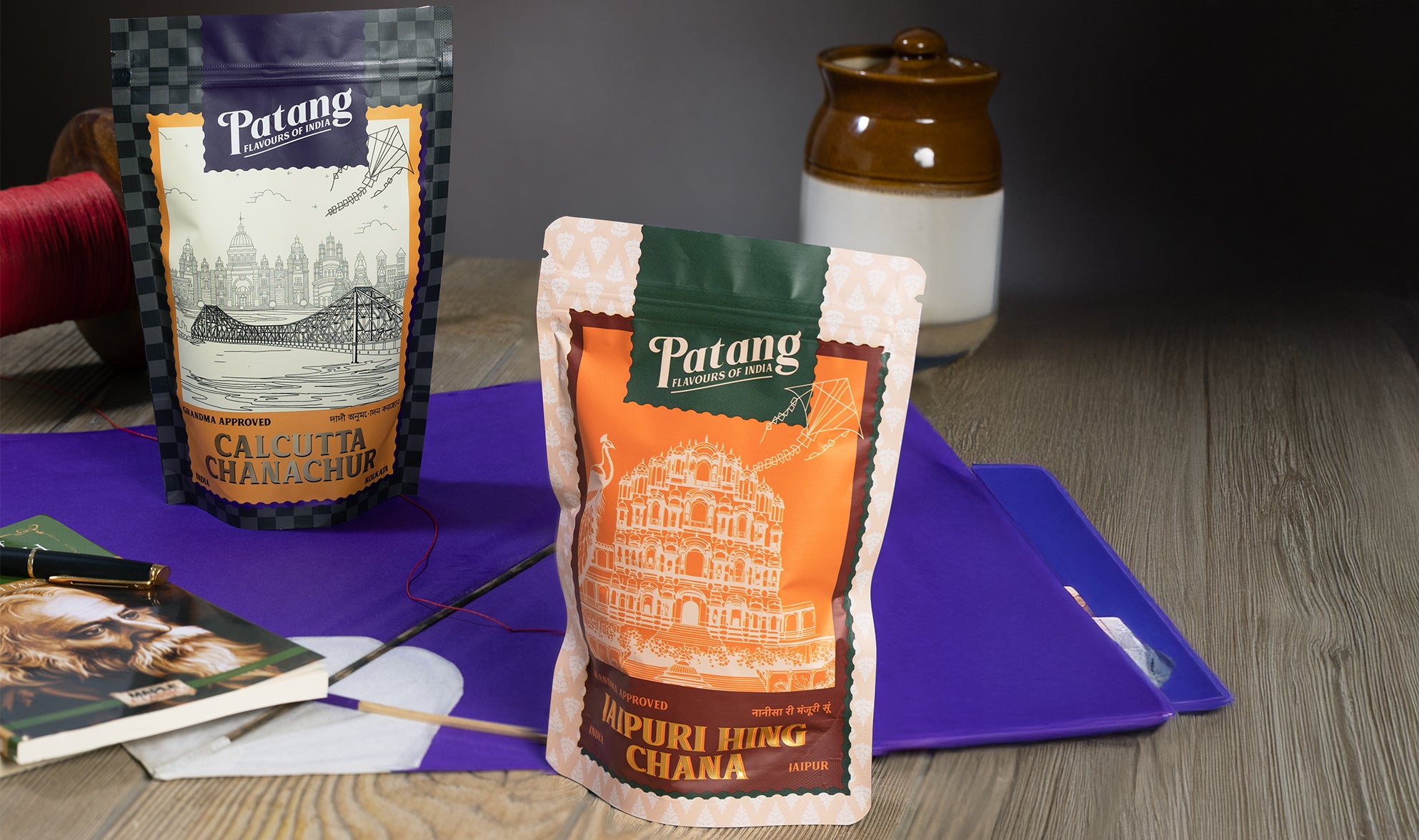 Two Patang tea packages on a purple cloth with a blurred background