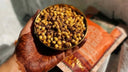 Hand holding a bowl of hing chana with a blurred background-desktop