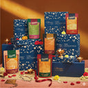 Collection of Patang products including boxes and packets on a decorative setup with flowers and candles.