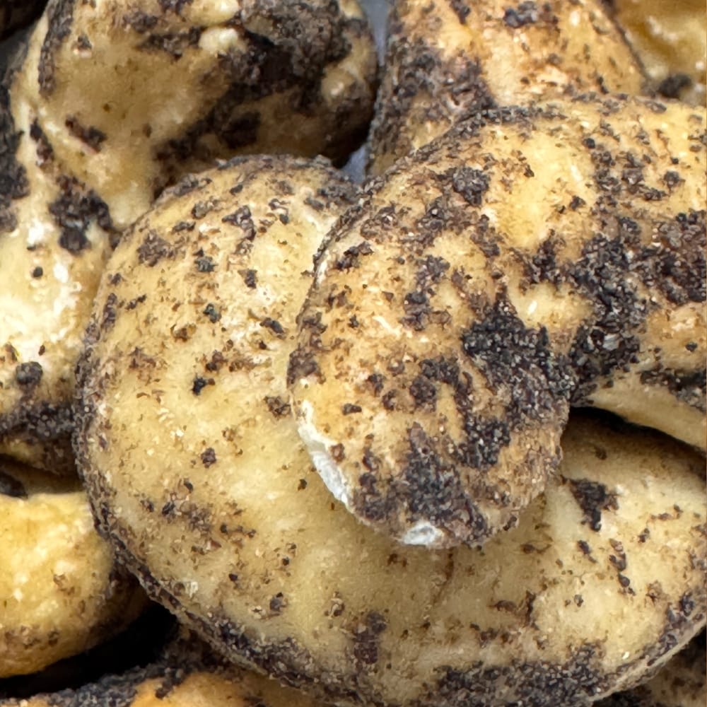 Close up of large roasted Thoothukudi cashews coated in freshly cracked black pepper, a premium healthy Indian snack
