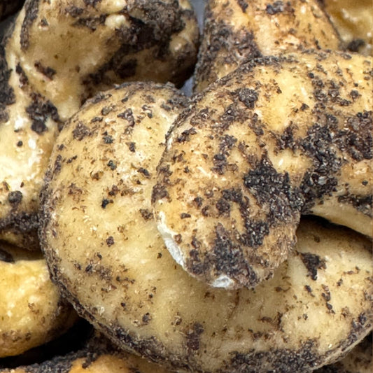 Close up of large roasted Thoothukudi cashews coated in freshly cracked black pepper, a premium healthy Indian snack
