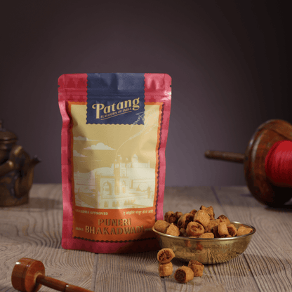 Patang Puneri Bhakadwao packaging with snacks on a wooden surface