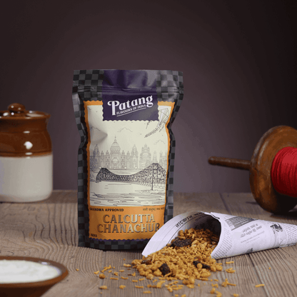 Patang Calcutta Chanachur spice packet on a wooden surface with a blurred background
