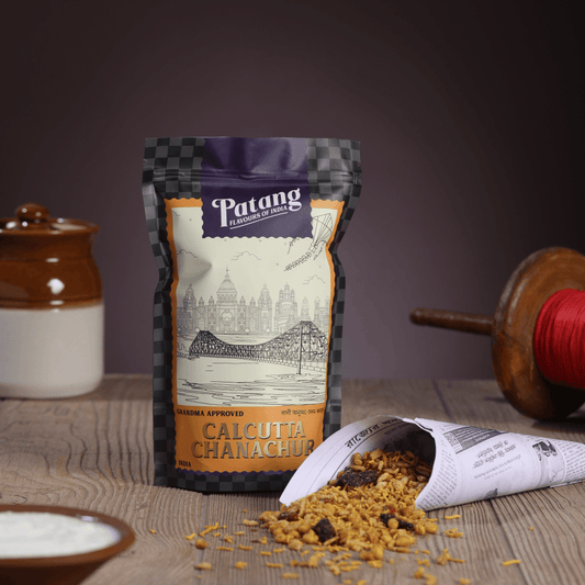 Patang Calcutta Chanachur spice packet on a wooden surface with a blurred background