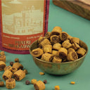 Bowl of Puneri Bhakdwis with packaging on a green background
