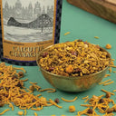 Bowl of Calcutta Chanach with packaging in the background on a green surface