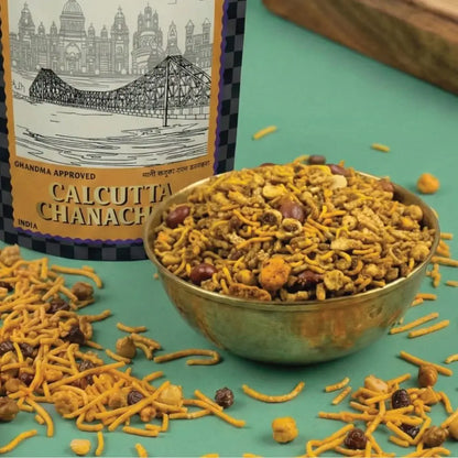 Bowl of Calcutta Chanach with packaging in the background on a green surface