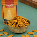 Bowl of Patang snacks with an orange packaging on a green background