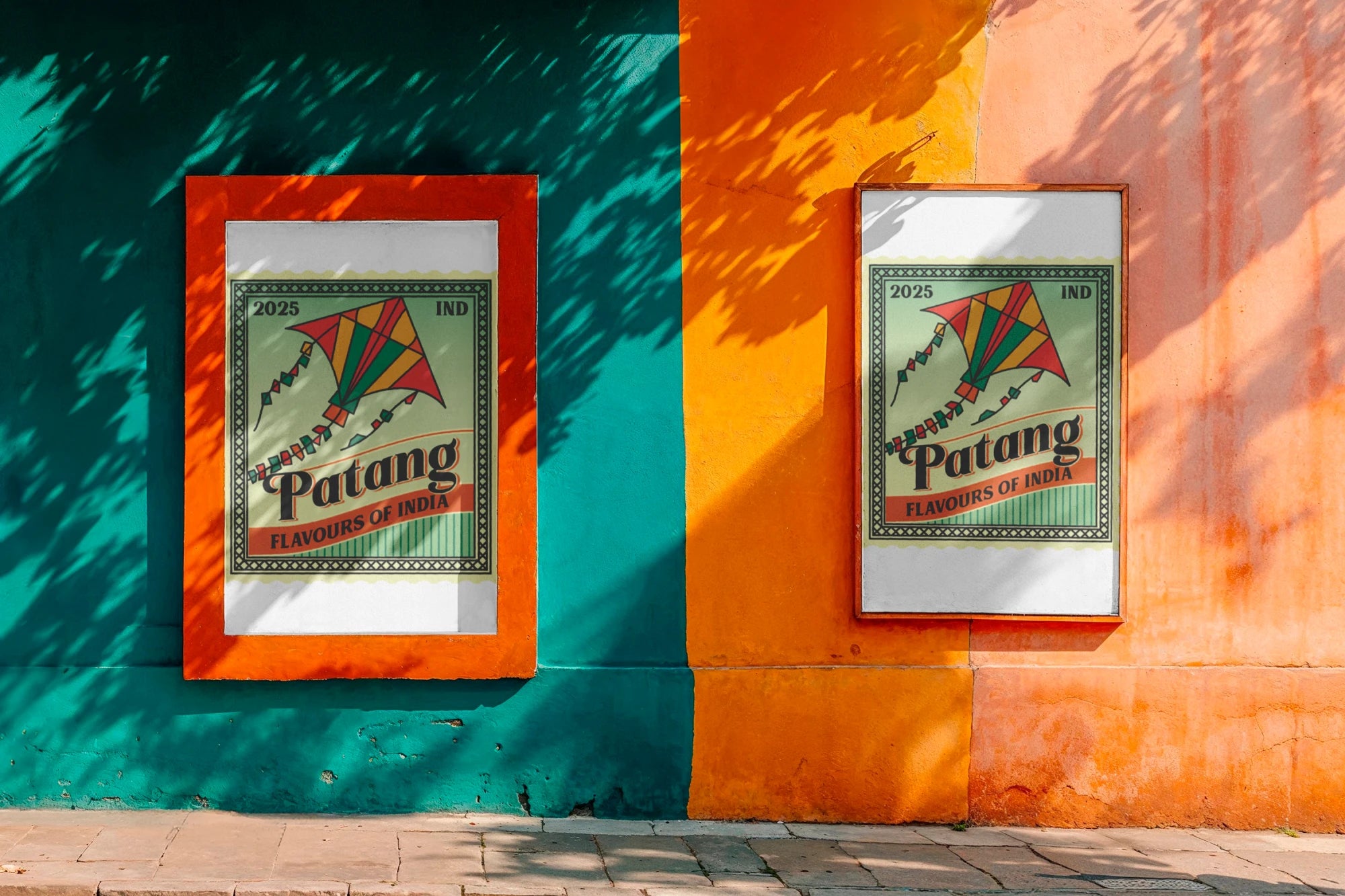 Two framed posters of Patang on a colorful wall.