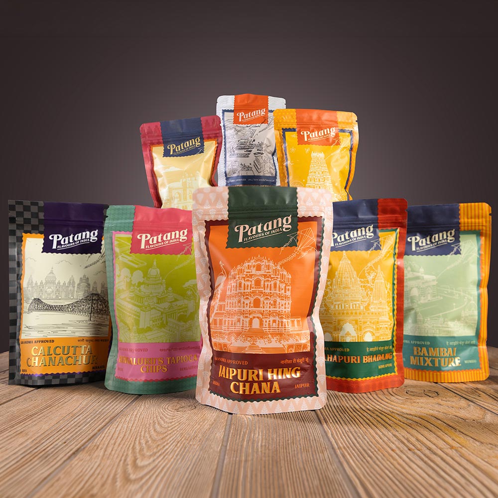 Collection of Patang brand food packages on a wooden surface with a dark background